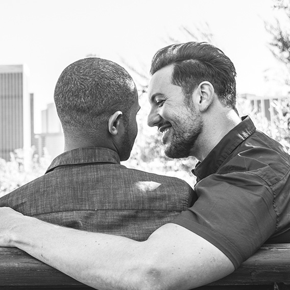 A couple looking at each other on a park bench