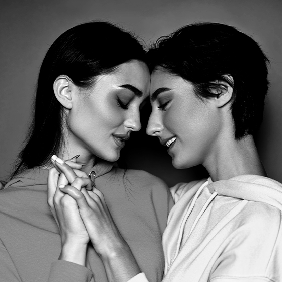 Two women holding hands with their heads together